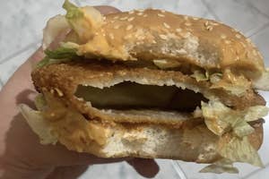 Hand holding a burger with an unexpected hollow patty, revealing an internet find of food gone wrong