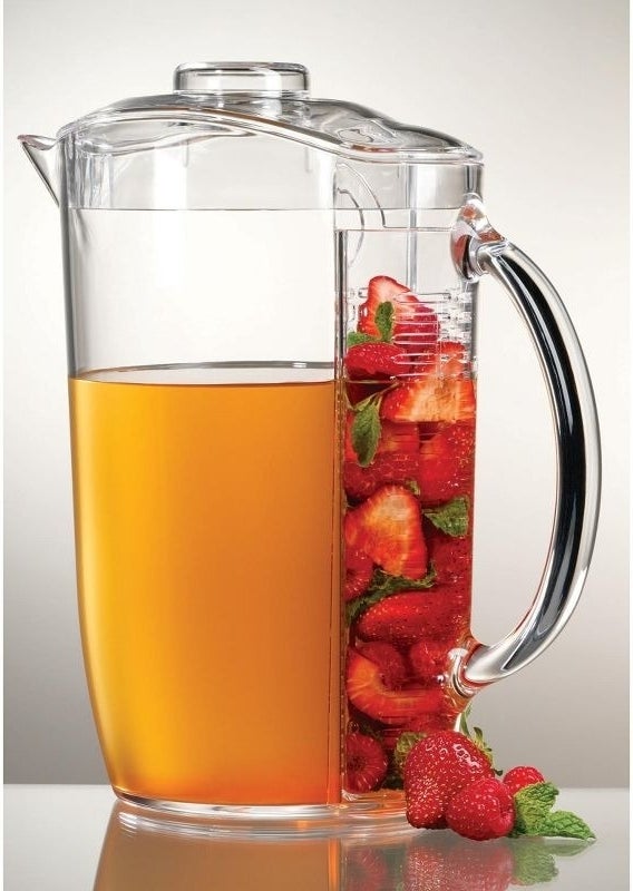 Pitcher with built-in infuser containing strawberries, ideal for making flavored beverages