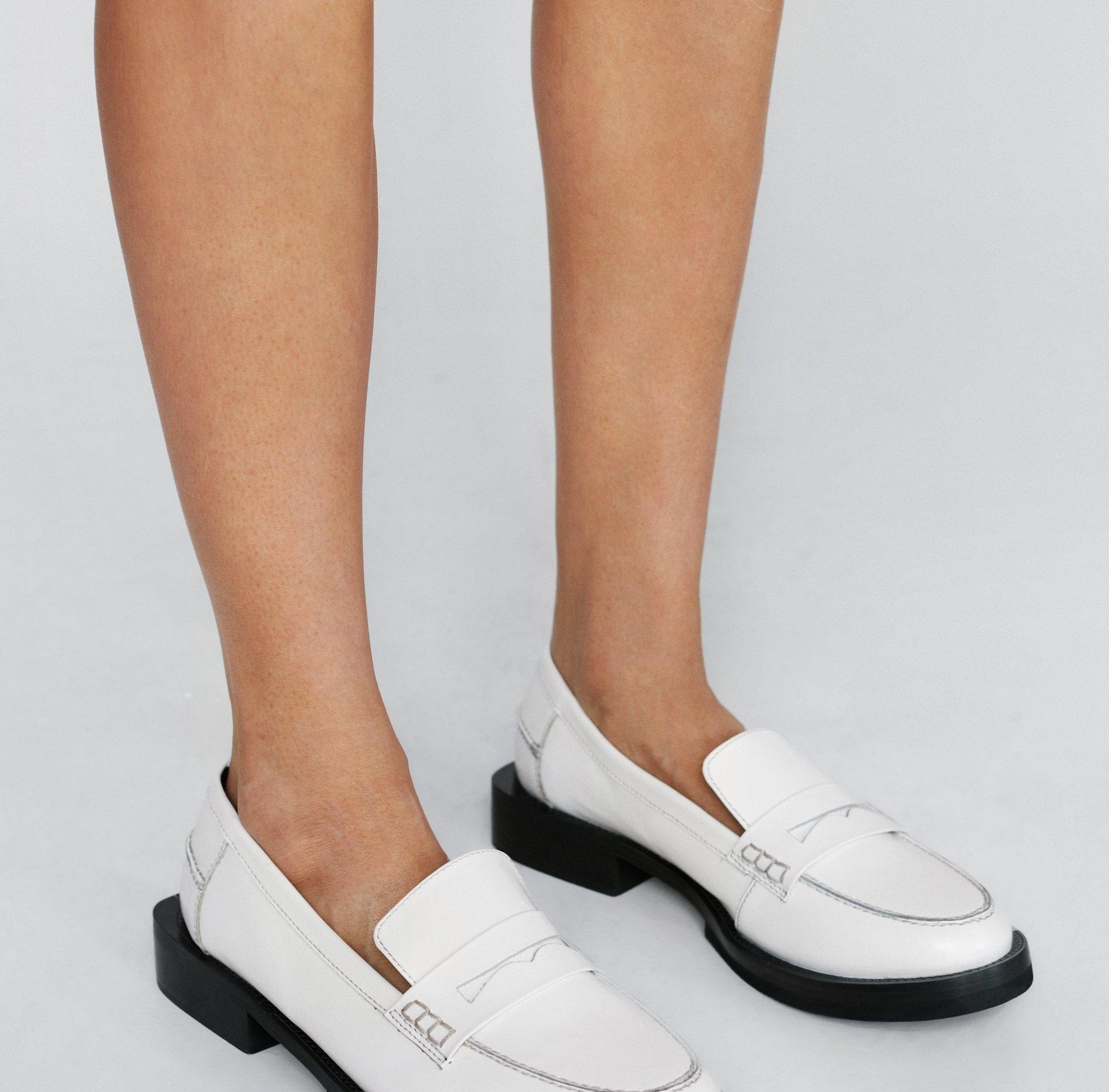 Person wearing fashionable loafers with thick soles, suitable for a shopping article