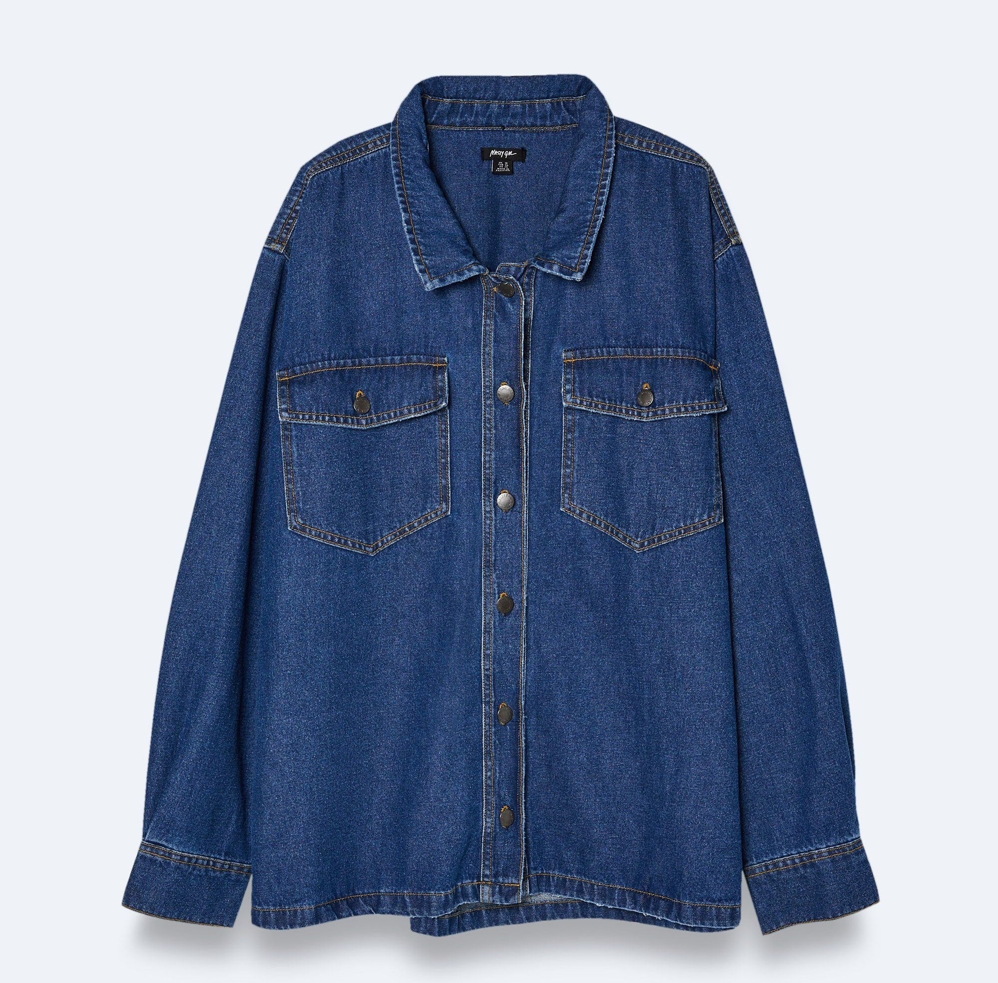 Denim shirt with button-up front and two chest pockets on a plain background, suggesting a casual style