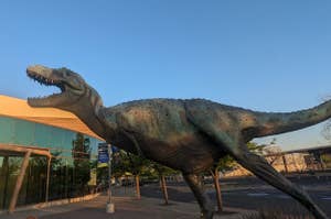建物の前に設置された恐竜の彫刻がある。