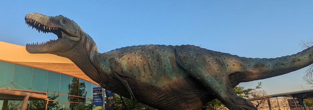 建物の前に設置された恐竜の彫刻がある。