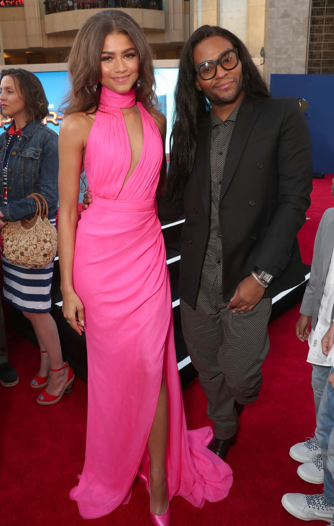Zendaya in a pink gown posing next to Law Roach in a black suit on a red carpet event