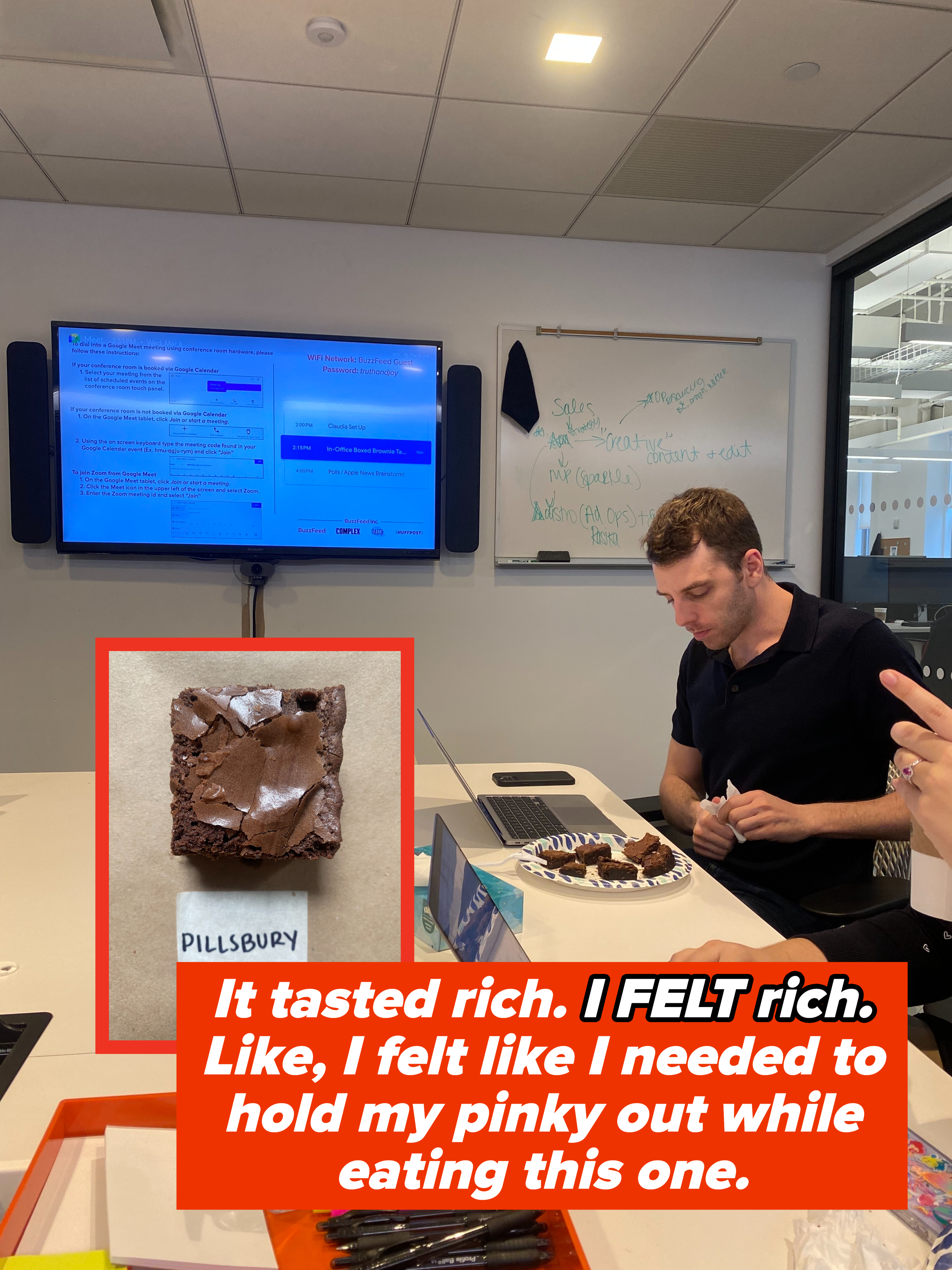 Person at a conference table with laptop and a plate of brownies nearby, in a casual office setting
