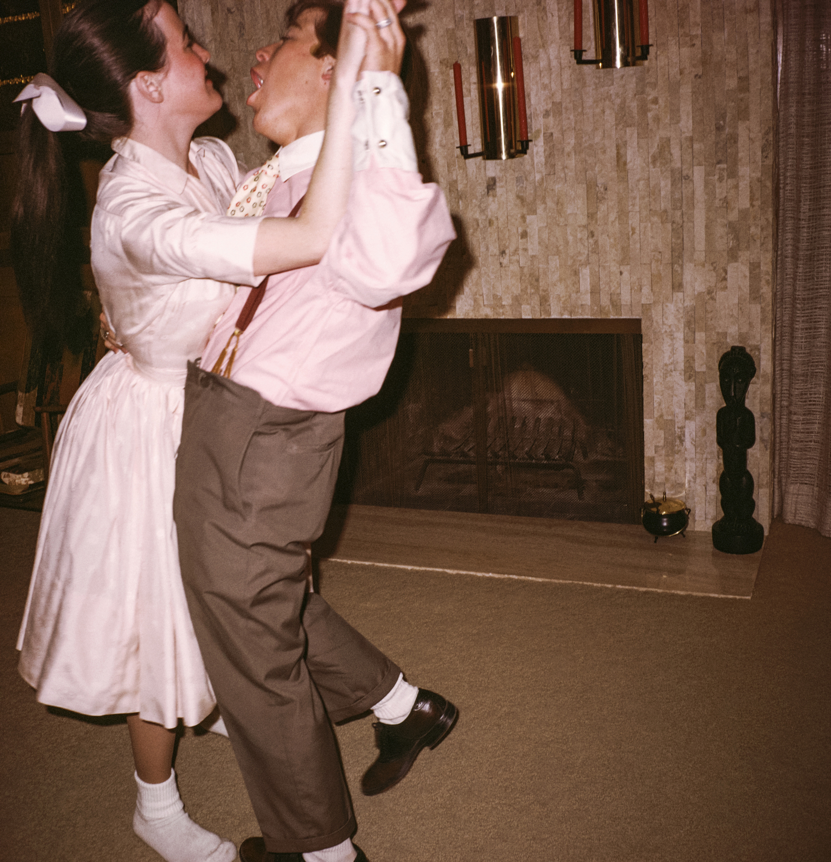 Two people joyfully dancing in a vintage-style living room