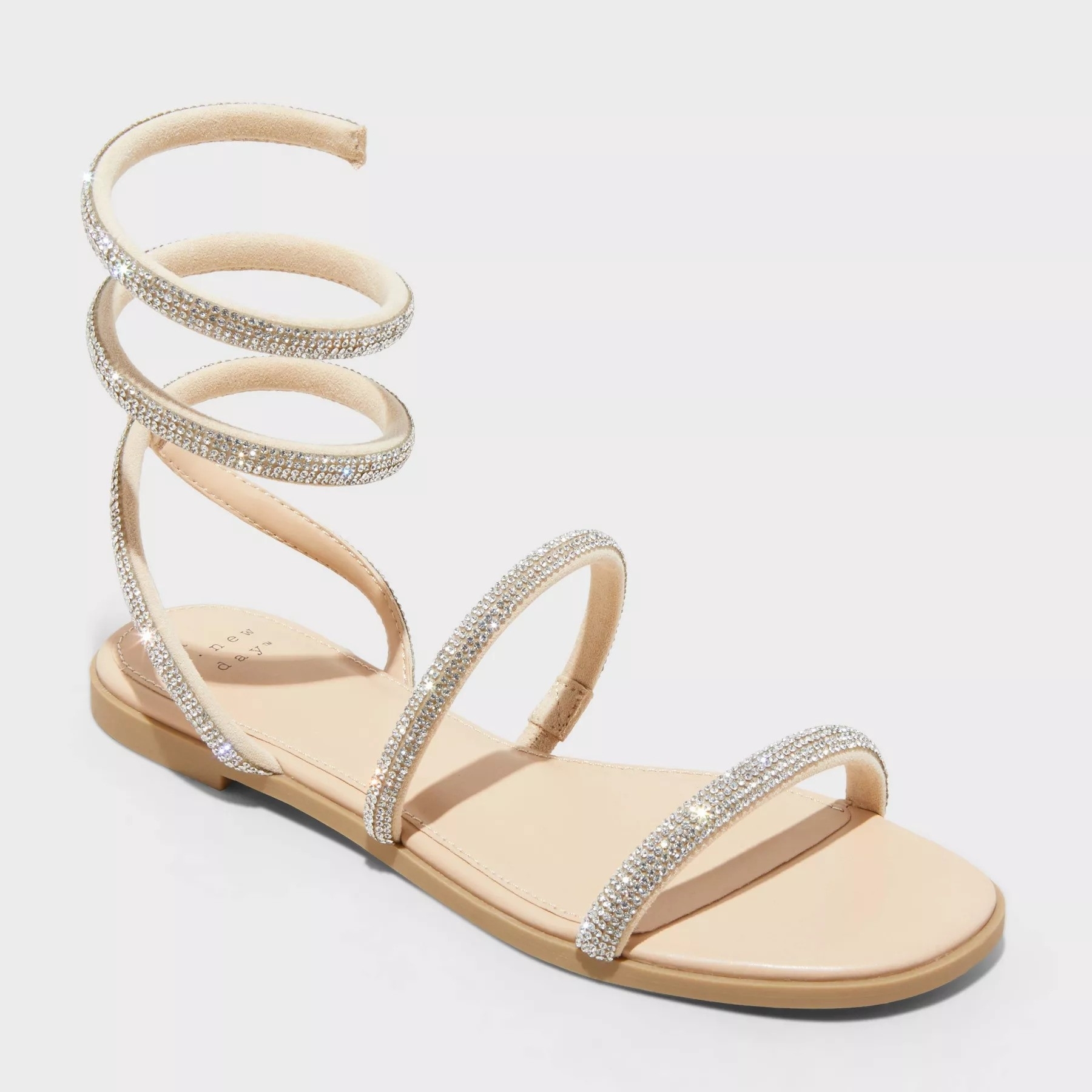 Gladiator-style flat sandal with spiral ankle straps and rhinestone embellishments