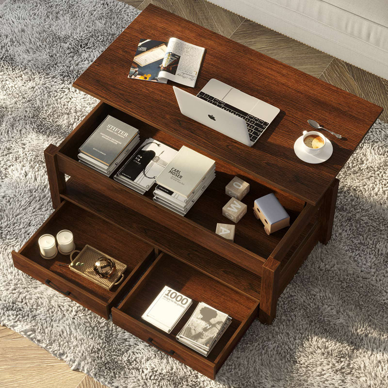 Wooden coffee table with open storage sections containing books, a laptop, and decorative items
