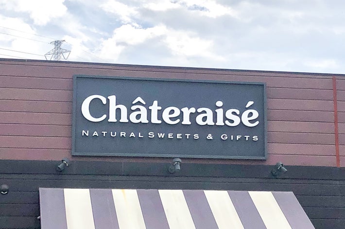 シャトレーゼの店舗の看板で、「NATURAL SWEETS & GIFTS」と書かれています。