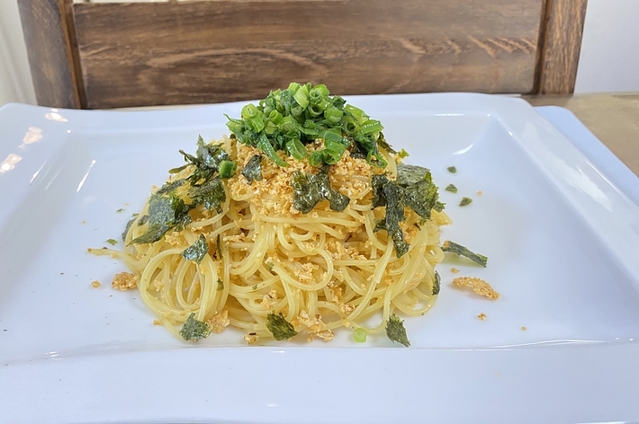 白い皿に盛られたパスタ、トッピングにネギと海苔