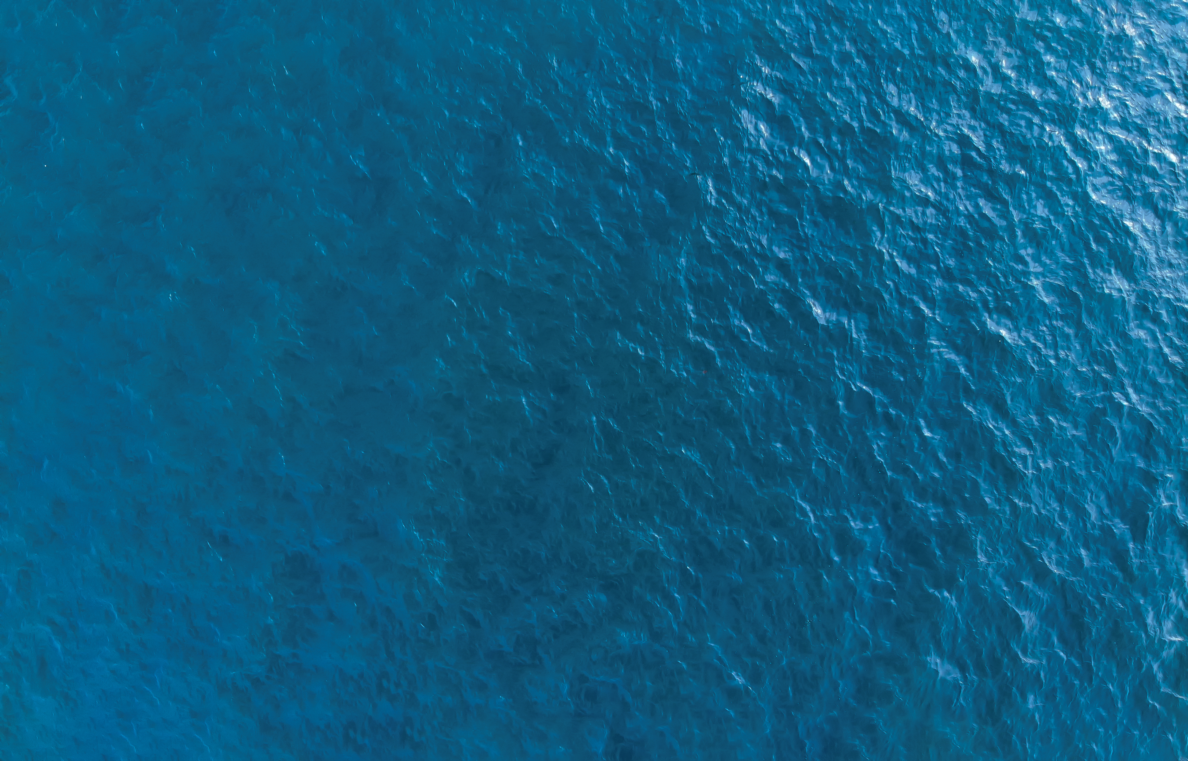 An aerial view of the ocean with rippling waves