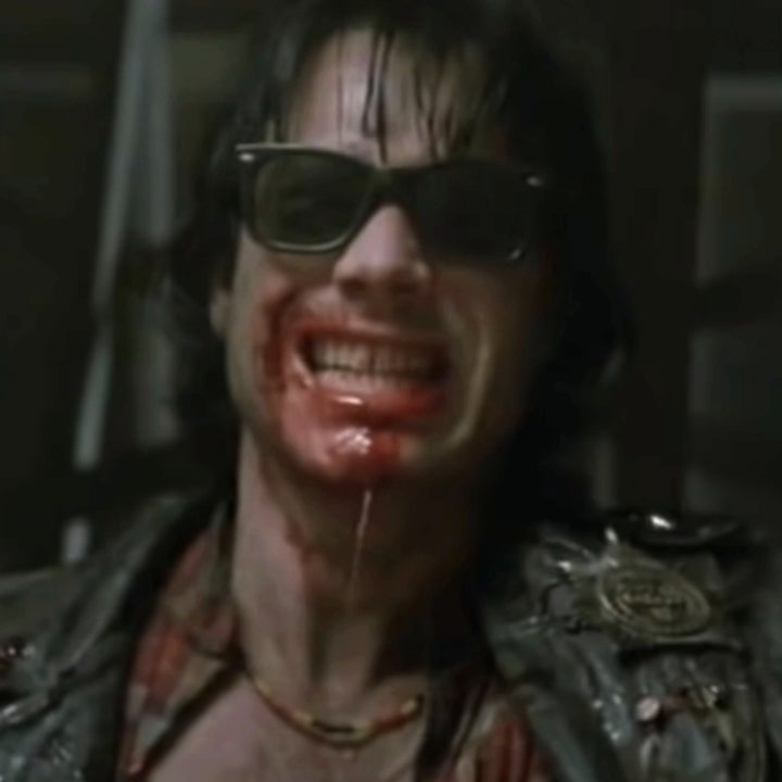 A character from the movie "Near Dark" with blood-soaked mouth, wearing sunglasses and a leather jacket, grinning menacingly