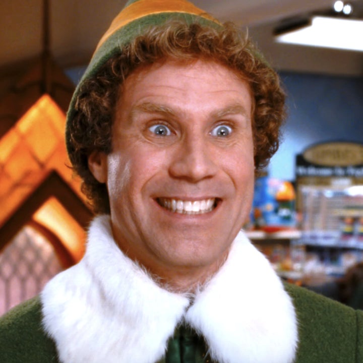 Will Ferrell as Buddy the Elf smiling widely in a scene from the movie "Elf" set in a festive store