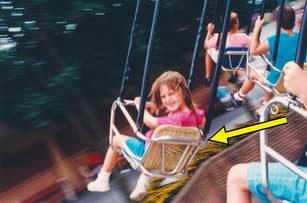 Child smiling on a carnival swing ride, indicated by a yellow arrow. Other children are also on swings in the background