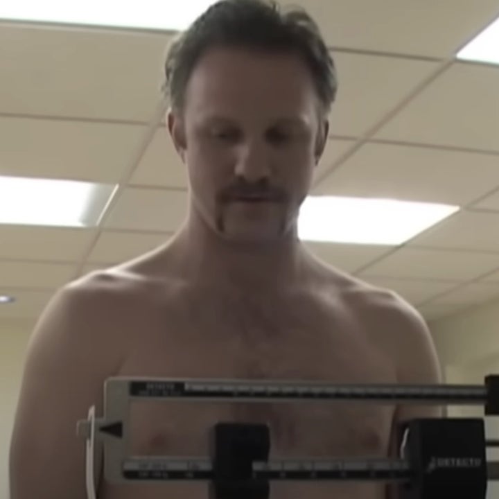 Morgan Spurlock stands shirtless on a scale, getting weighed by a person on the right, while another person looks on from the left