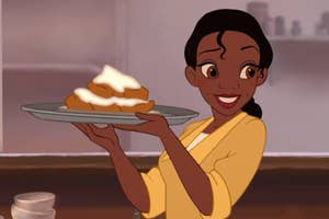 Tiana from The Princess and the Frog" happily holds a tray of beignets in a kitchen