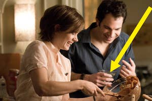 Amy Adams and Ron Livingston cooking together, laughing while she mixes batter in a bowl. Ron holds a drink, enjoying the moment in a kitchen setting