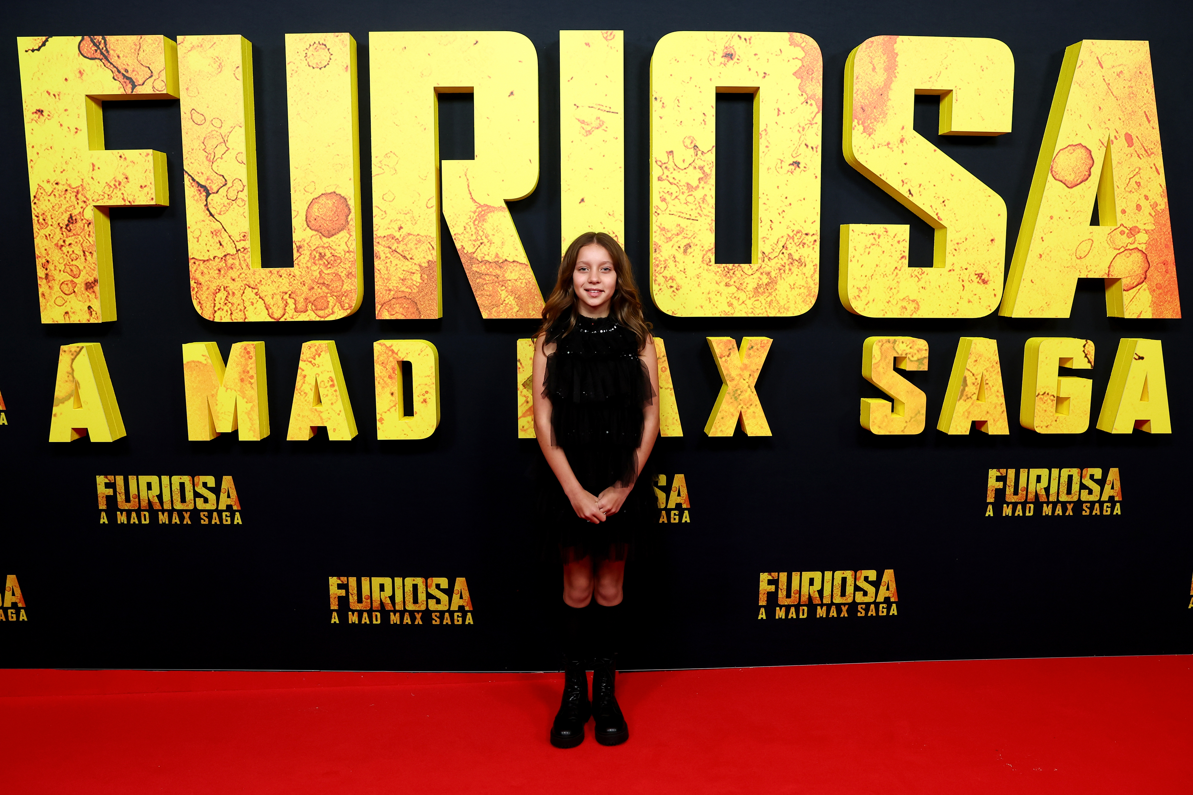 Dylan Adonis wearing a black dress and knee-high socks at the Australian premiere of "Furiosa: A Mad Max Saga"