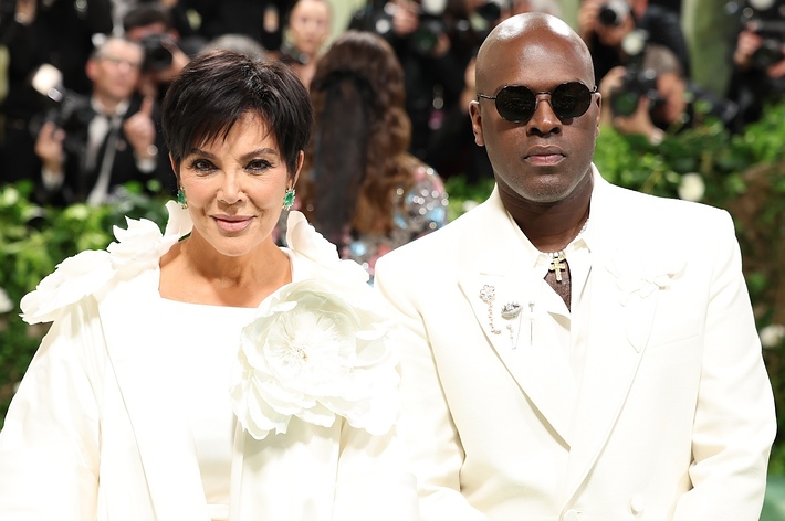 Kris Jenner and Corey Gamble at a public event, both wearing stylish white outfits