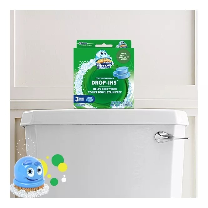 Scrubbing Bubbles Drop-Ins package on top of a toilet tank. The image includes the product and its cartoon mascot in the bottom left corner