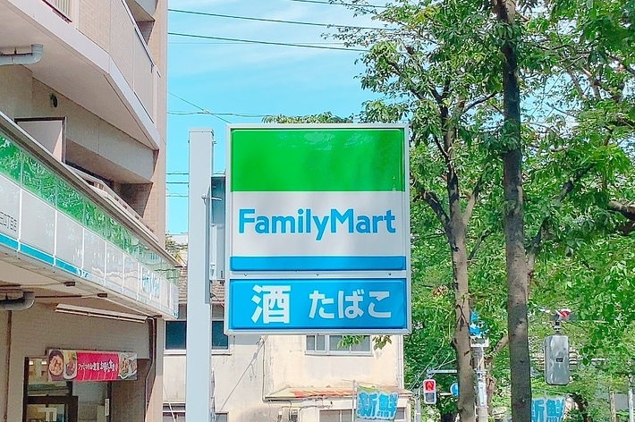 ファミリーマートの看板。その下に「酒 たばこ」と表示されています。店舗の外観が見えます。