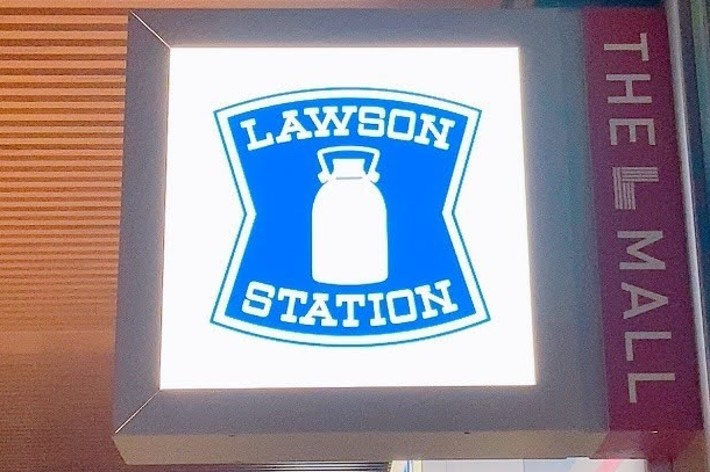 ローソンの看板、「LAWSON STATION」と書かれたミルク缶のロゴ。隣に「THE MALL」と書かれた看板があります。
