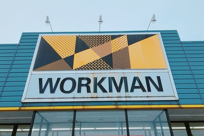 「WORKMAN」と書かれた看板。幾何学模様のデザインが施されている店舗の外観。