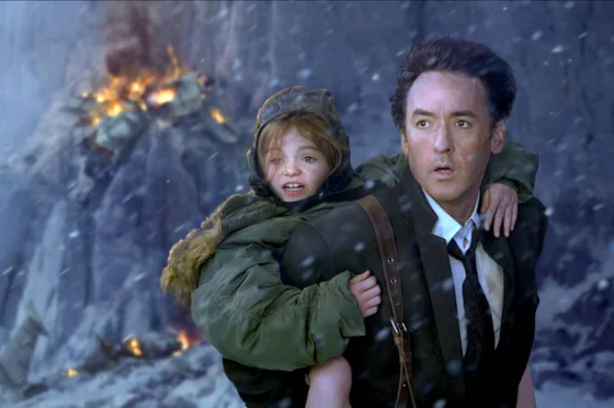 John Cusack carries a young girl on his back as they flee an explosion amidst snowy terrain in a dramatic scene