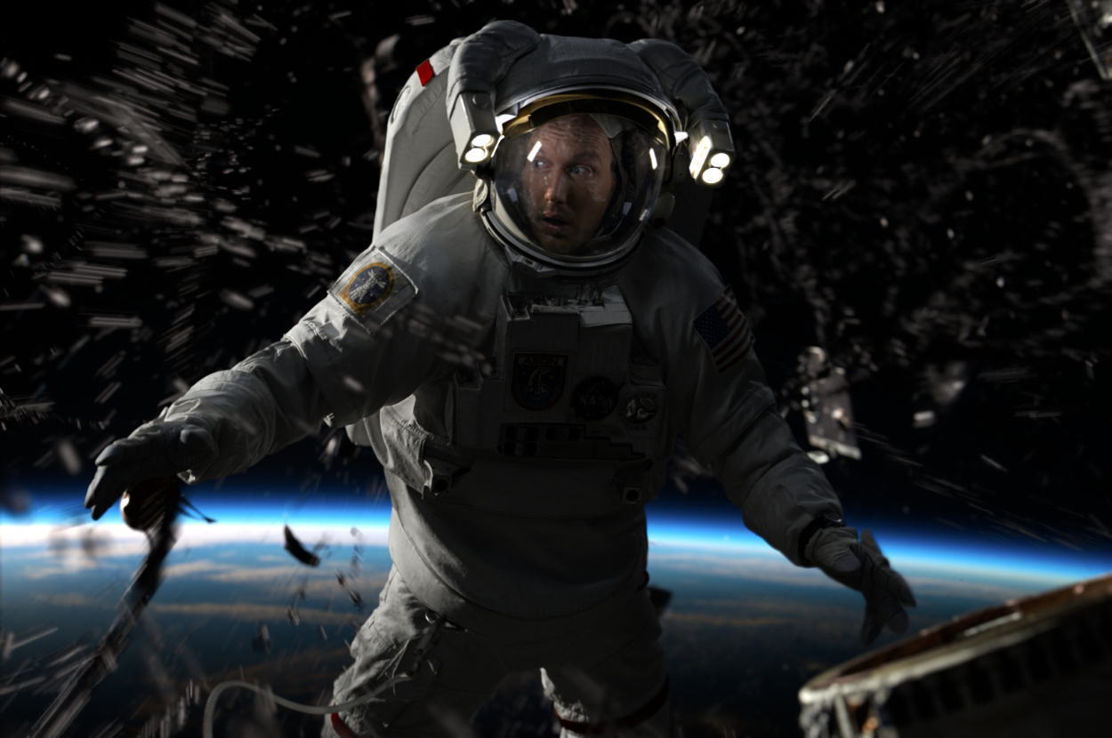 Astronaut floating in space with the Earth in the background, illuminated by lights on helmet. Large debris is seen surrounding the astronaut