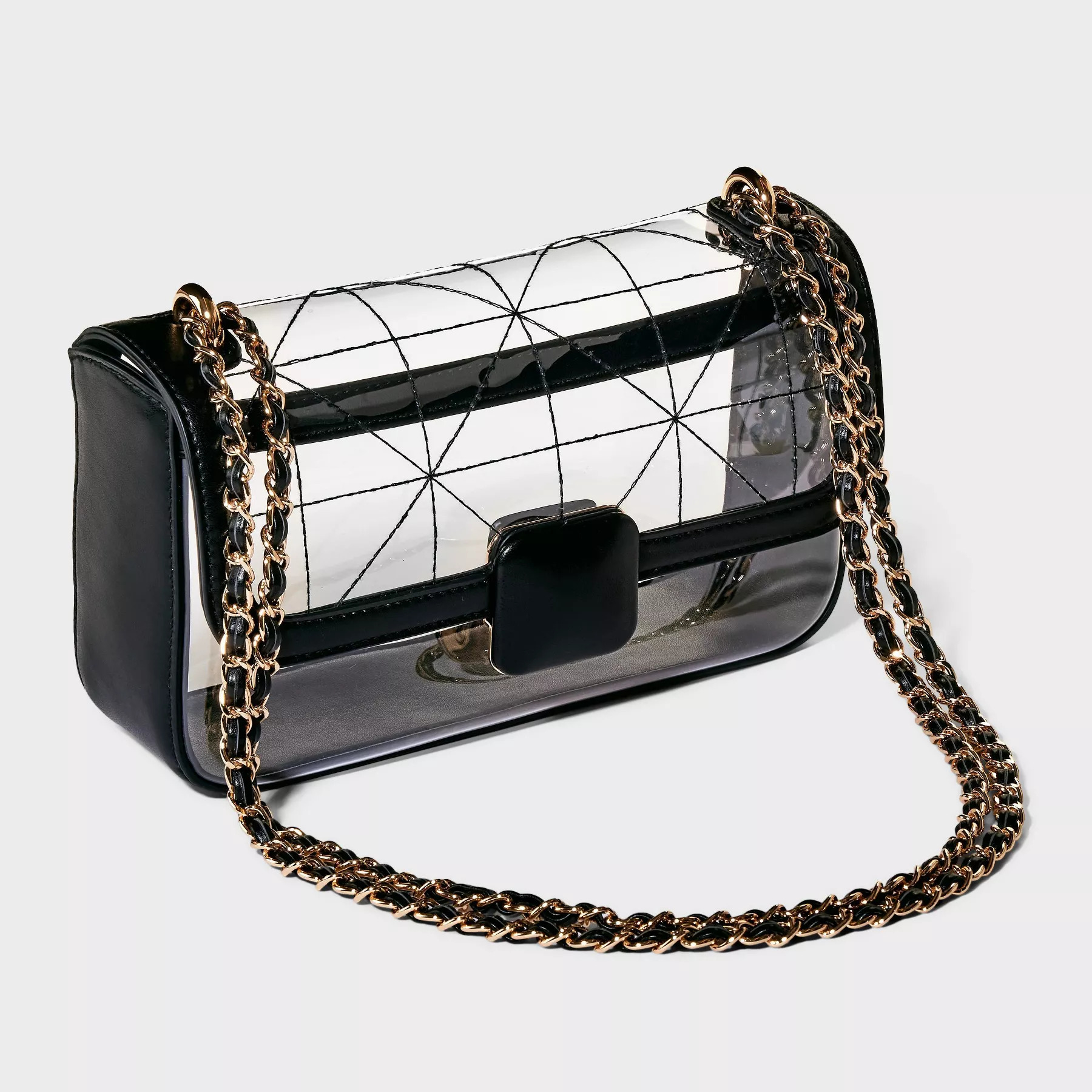 Clear purse with a geometric grid design, black side panels, and a gold chain strap