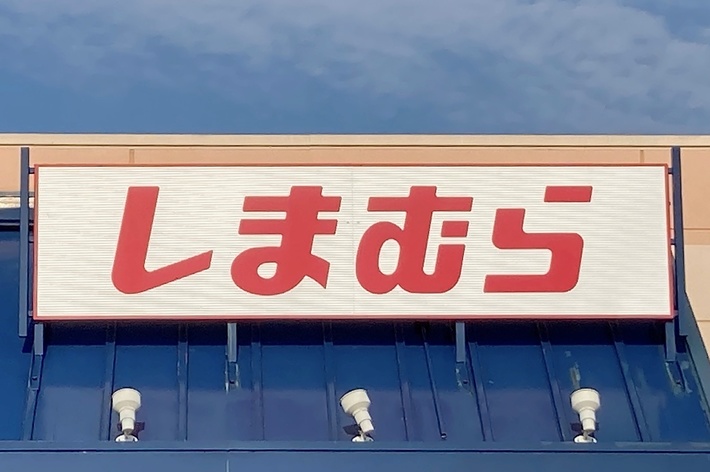 Storefront with a sign featuring Japanese characters. Accessible parking sign is visible in front