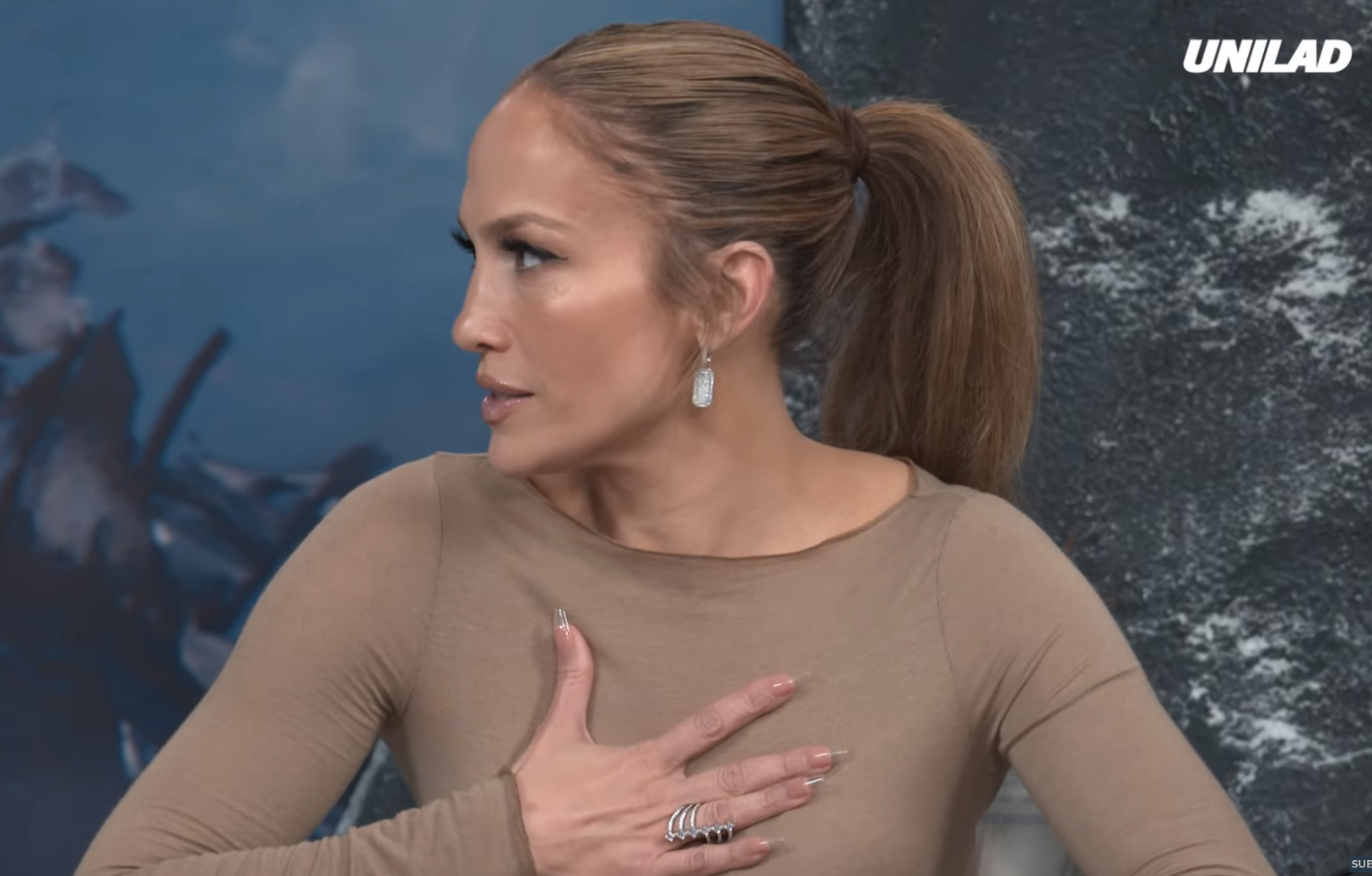 Jennifer Lopez discusses AI-related fears in an interview clip from "The Vault" alongside Simu Liu and Sterling K. Brown, as shown on the Unilad YouTube channel