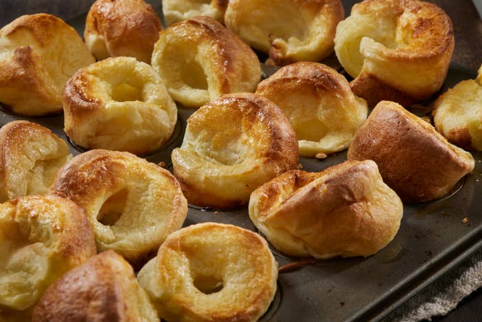 A tray of freshly baked Yorkshire puddings, golden and puffed up, ready to be served