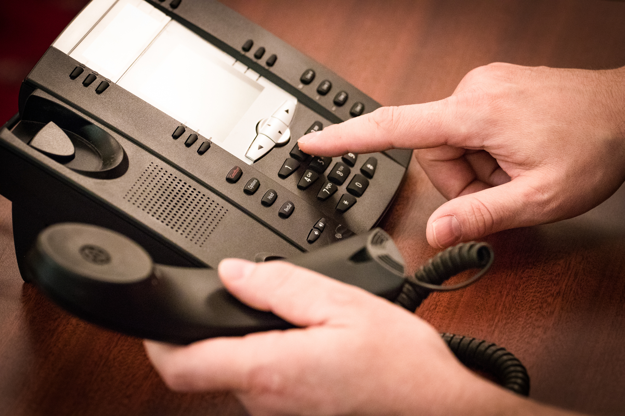 Person dialing a number on a landline phone while holding the receiver. The image is part of an "Internet Finds" article