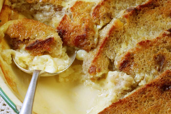 Close-up of a creamy bread pudding with a spoon scooping out a portion