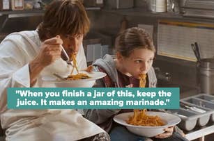Jim Carrey in chef's jacket and young Abigail Breslin eat spaghetti in a kitchen