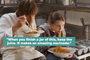 Jim Carrey in chef's jacket and young Abigail Breslin eat spaghetti in a kitchen