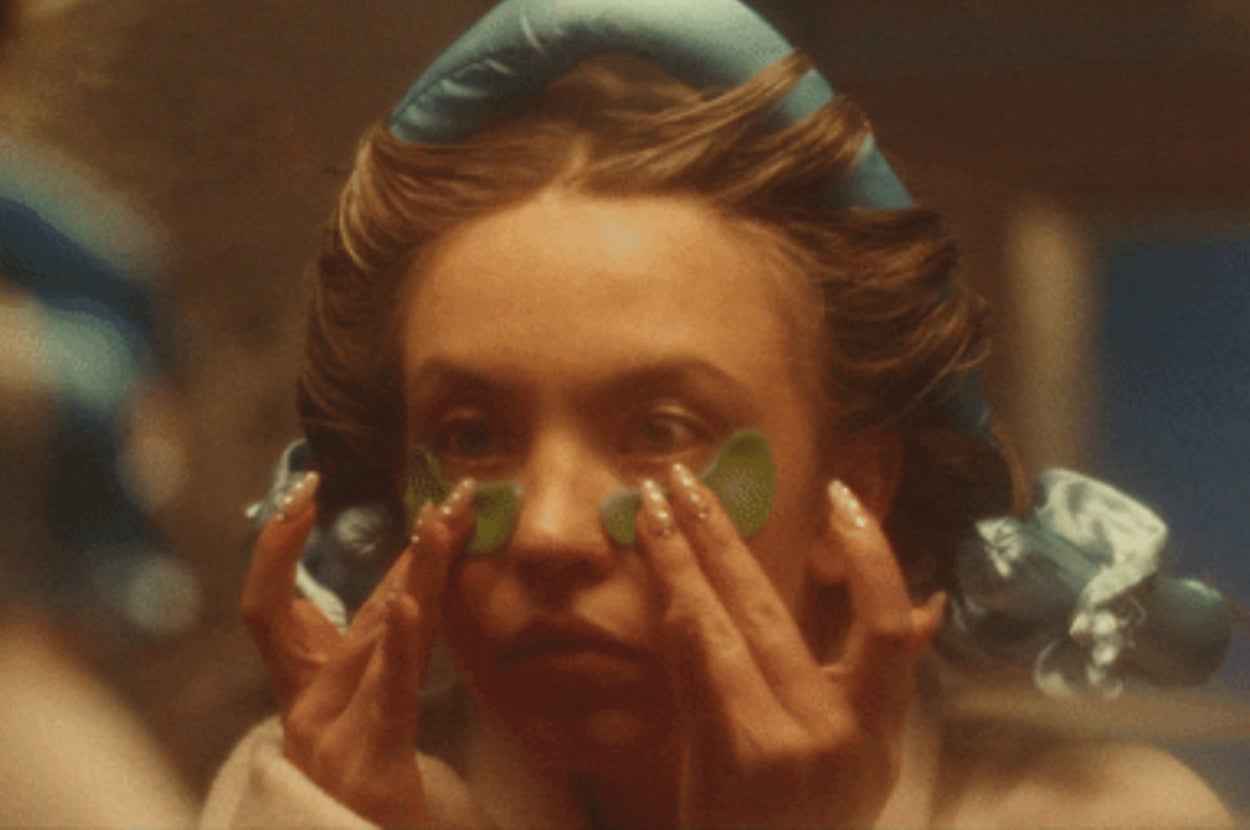 Sydney Sweeney applies under-eye patches with hair curlers in, focusing on her skincare routine