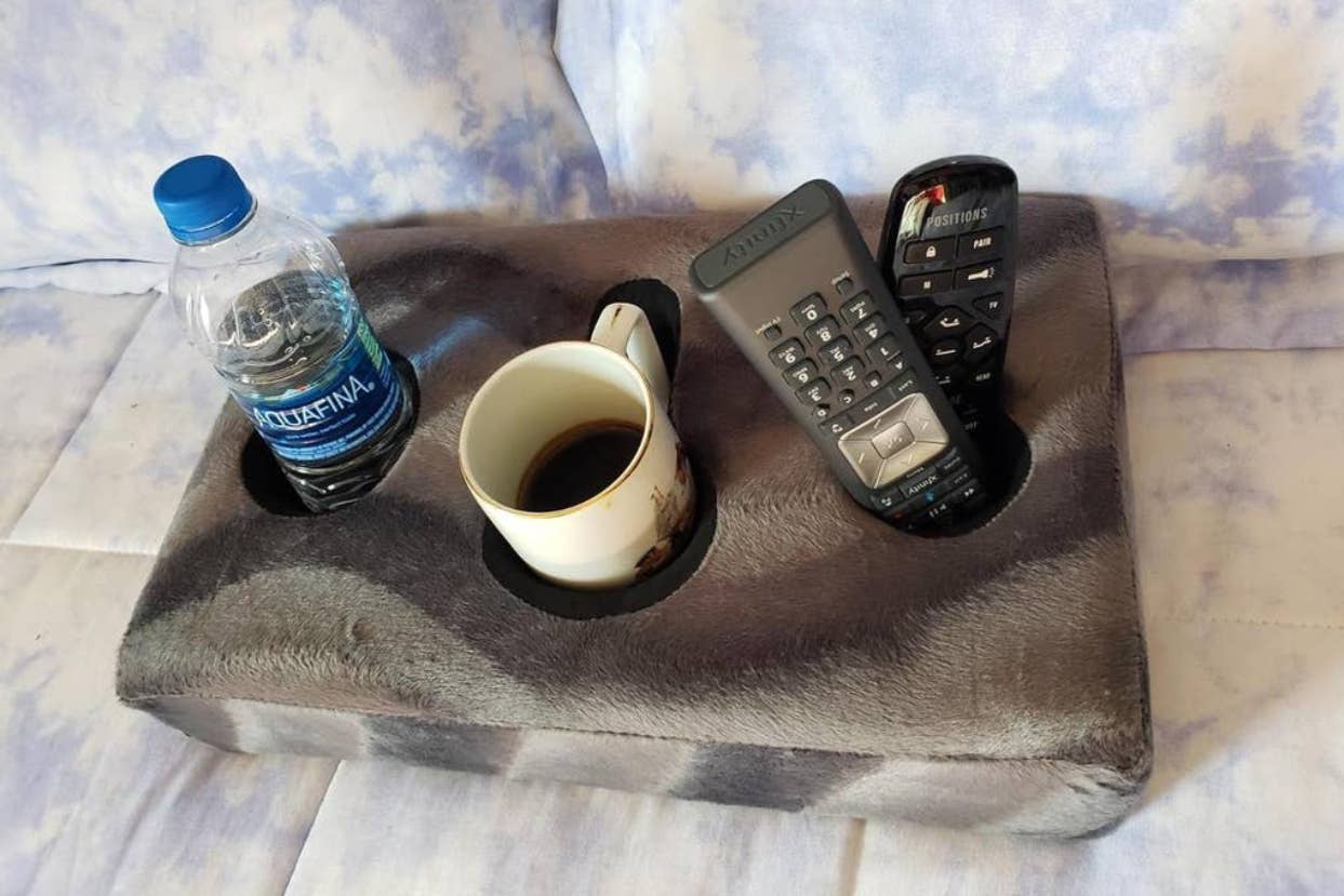 grey cup cozy holding water bottle, mug, and remotes