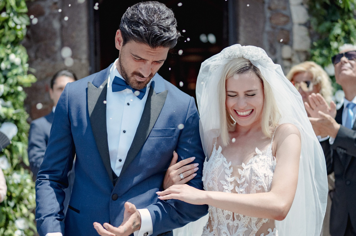 A couple in a blue tux and a wedding gown walking outside after their wedding ceremony