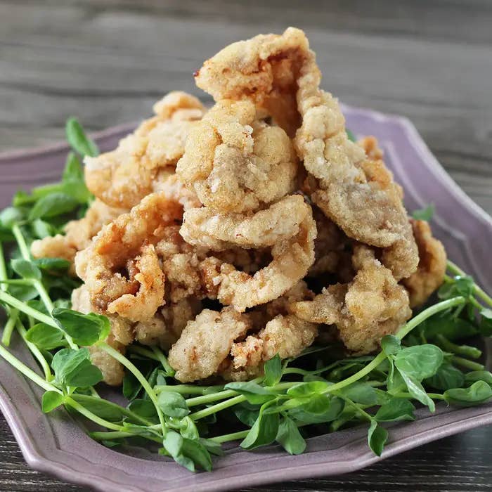 野菜の上に乗った揚げた豚こま切れ肉の盛り合わせ。