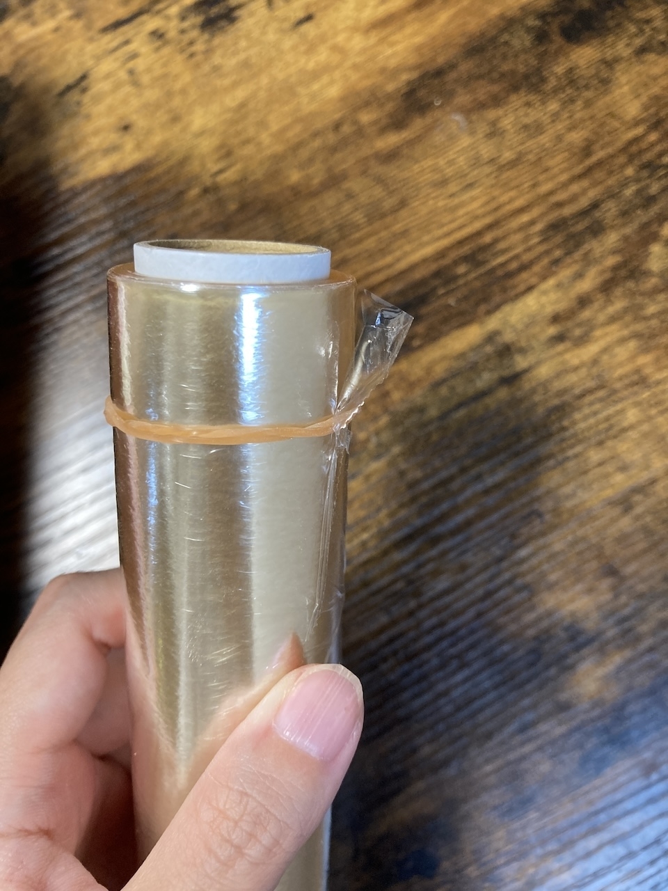 手に持たれた透明なロール状の包装フィルム