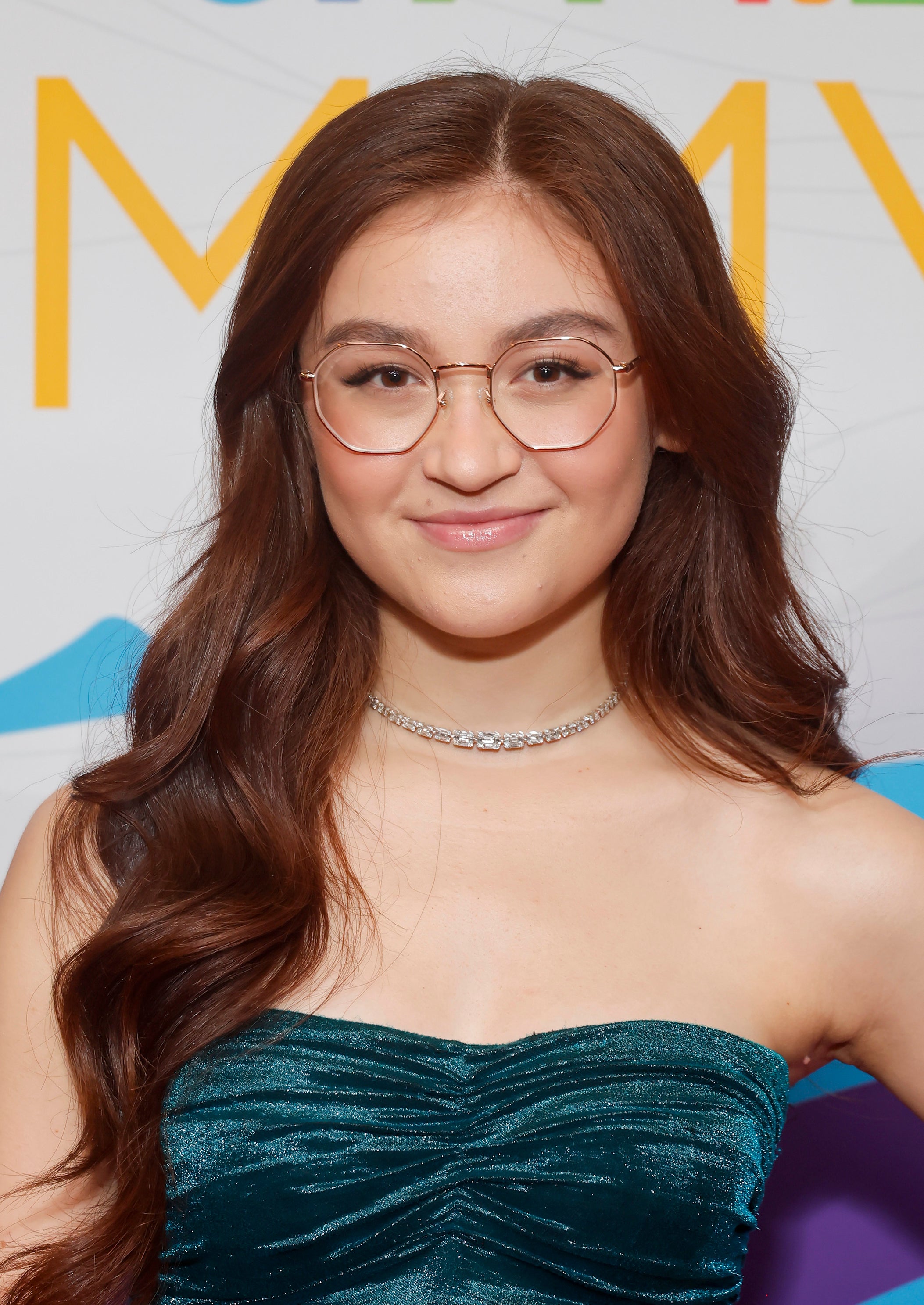 Anna Cathcart at event wearing a teal strapless top and a choker necklace