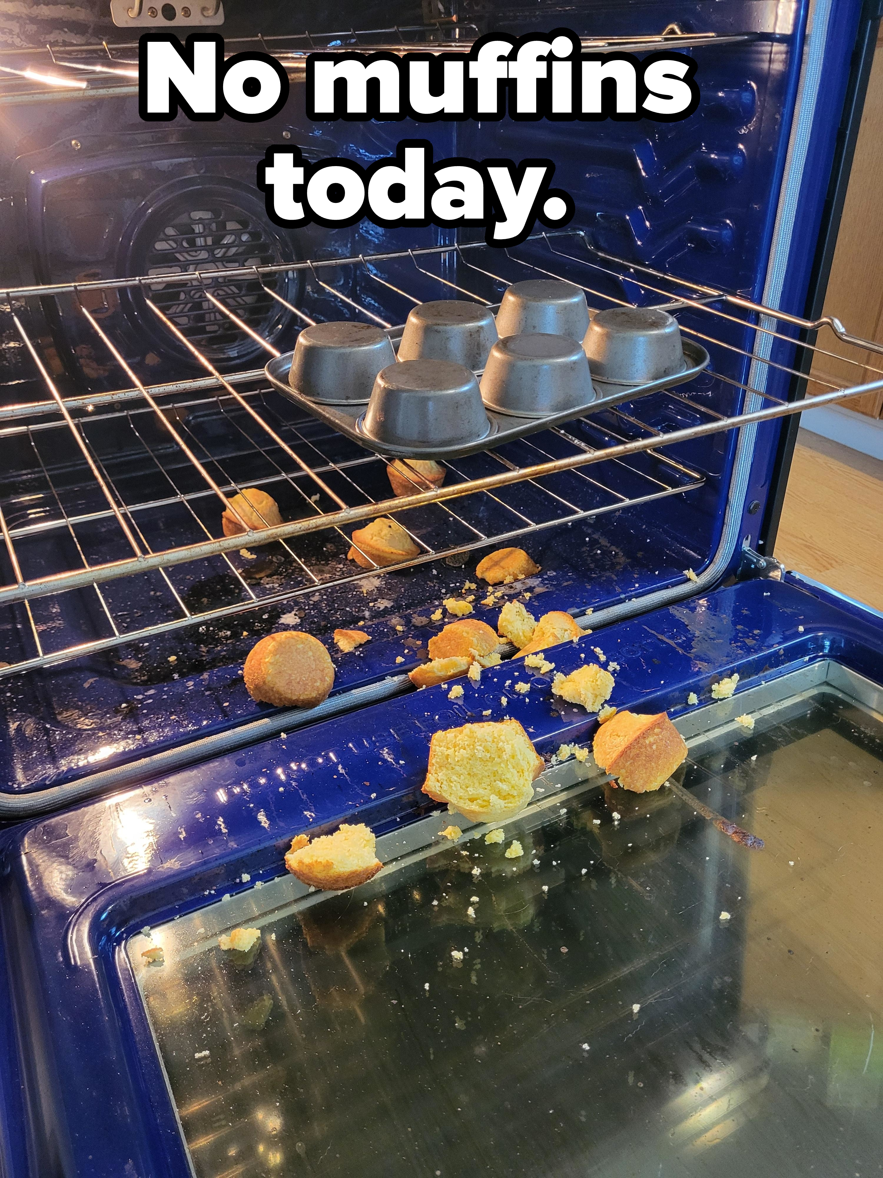 Exploded cupcakes on an oven floor with a metal tray and intact cupcakes above