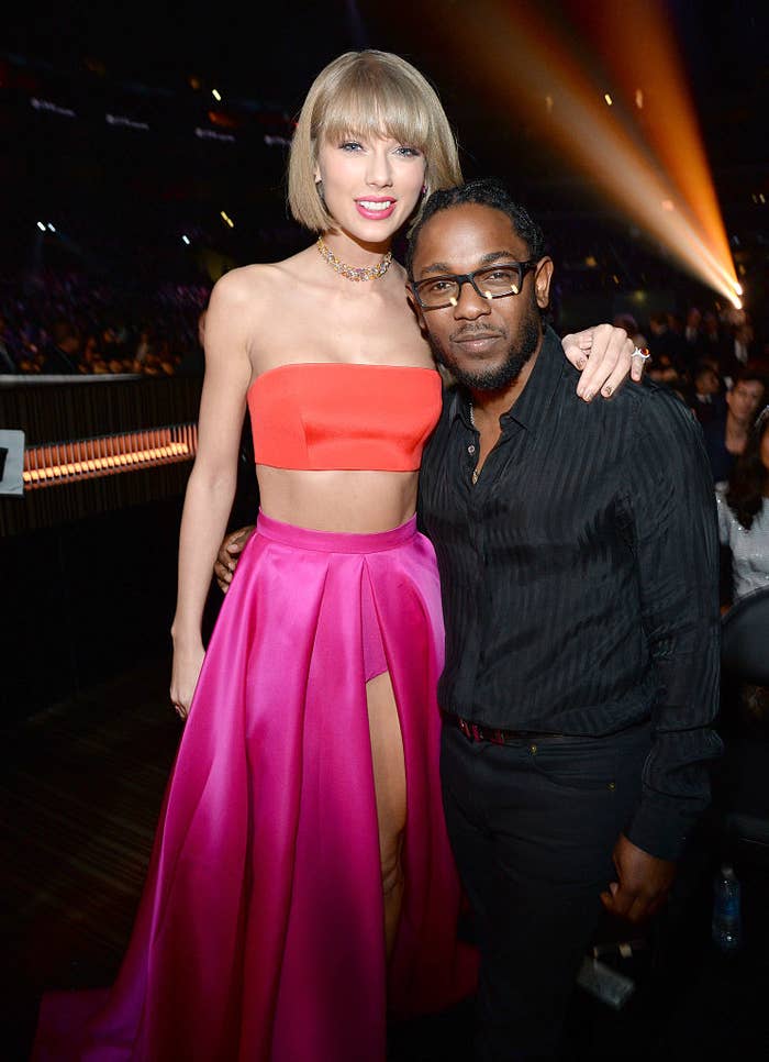Taylor Swift in a crop top and high-slit skirt posing with Kendrick Lamar at an event