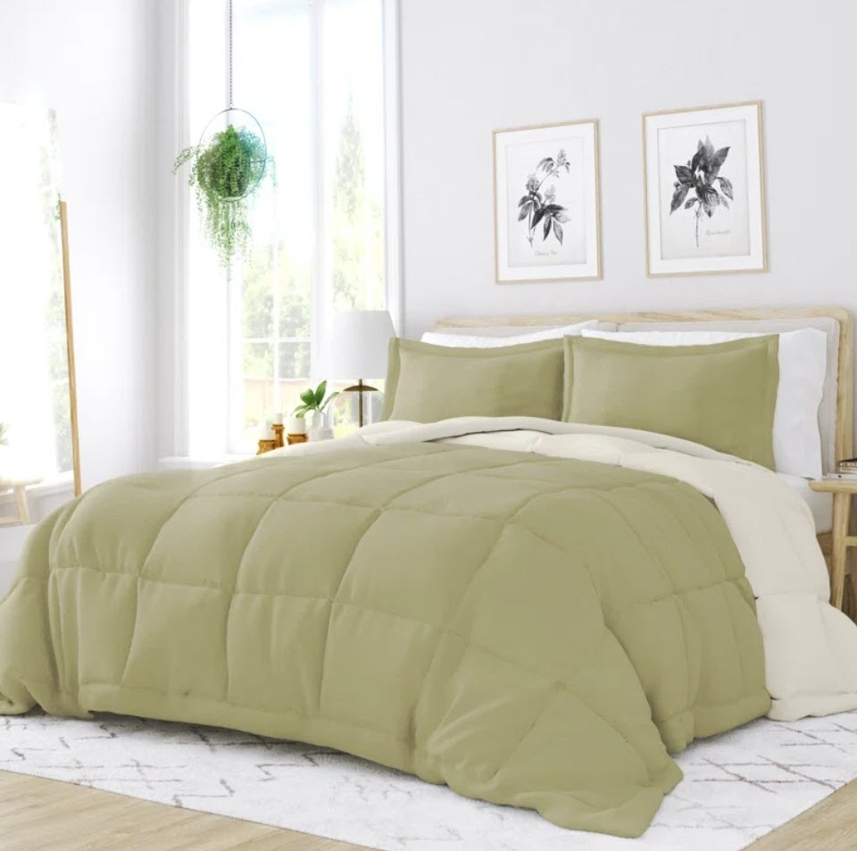 A neatly made bed with a plain green comforter set in a bright bedroom, ideal for highlighting home decor in a shopping article