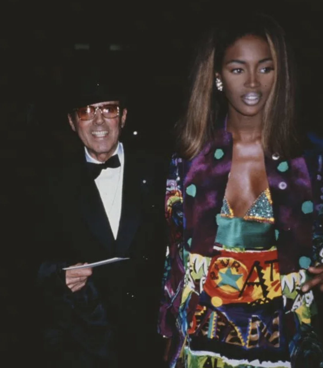 Naomi Campbell con vestido de grafiti junto a Gianni Versace en esmoquin clásico