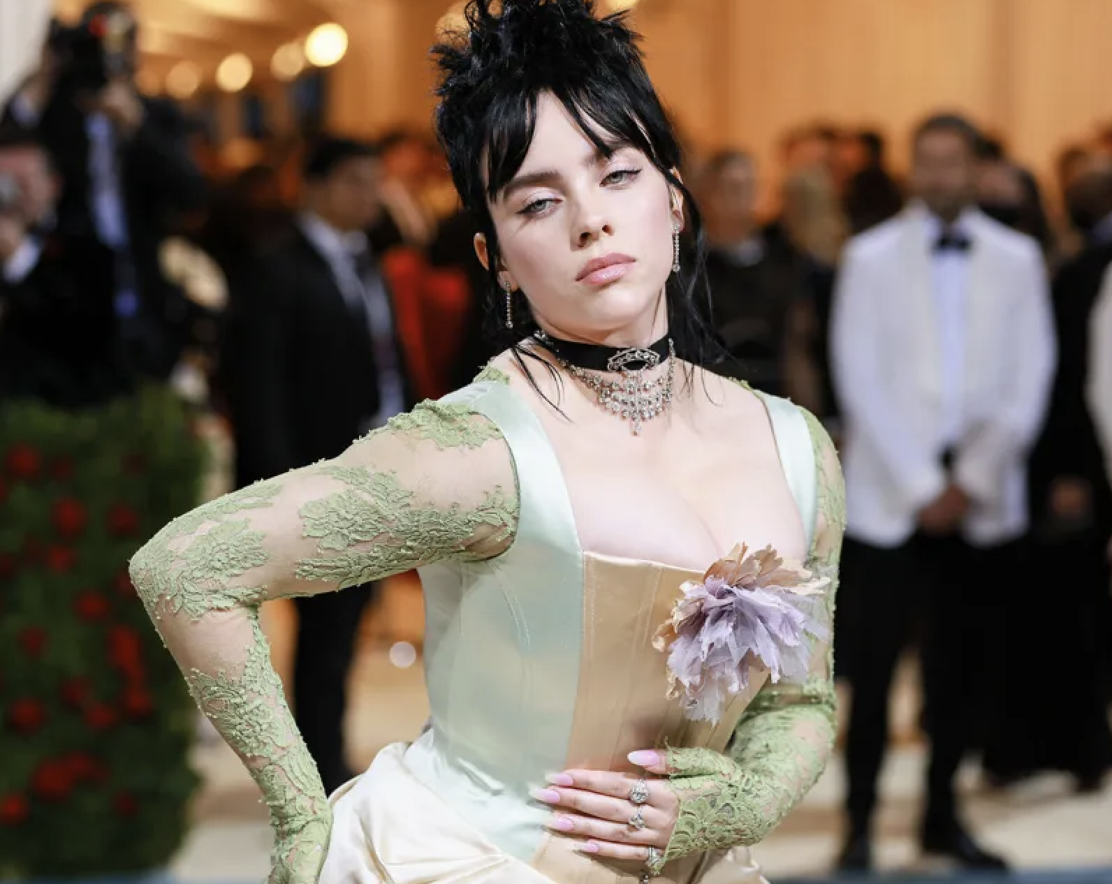 Billie Eilish posa con un vestido ajustado de encaje y guantes a juego en un evento