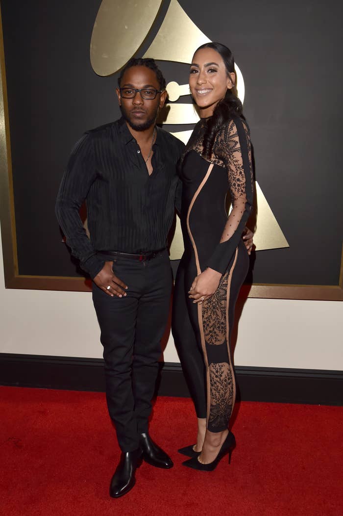 Kendrick Lamar in a black shirt and pants with a guest in a lace-detailed black dress at the Grammys