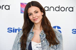 Victoria Justice poses in a denim jacket and Prada top at a media event