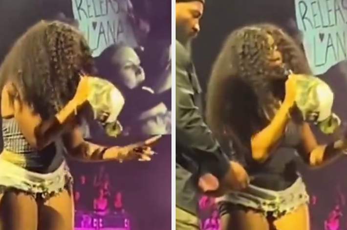 Music artist on stage wearing a sparkly outfit, interacting with a fan holding a sign